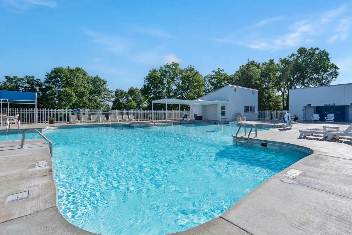 A sparkling outdoor swimming pool with poolside seating and a shaded cabana area, creating a welcoming space for swimming, sunbathing, and social gatherings.